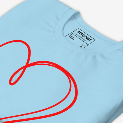 Angled view of neatly folded light blue t-shirt showcasing the red heart design - product detail.