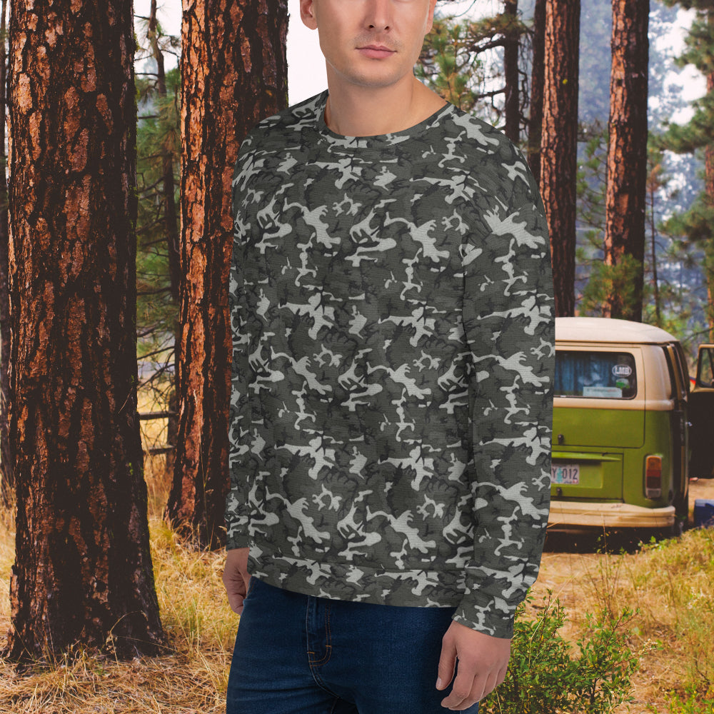 Man standing outdoors wearing a camo sweatshirt in a forest setting