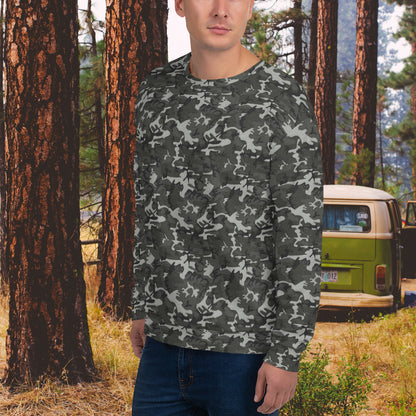 Man standing outdoors wearing a camo sweatshirt in a forest setting