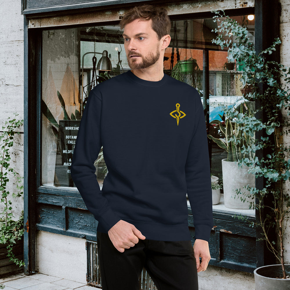 Casual navy sweater with a bold needle and thread motif on a man in an urban setting