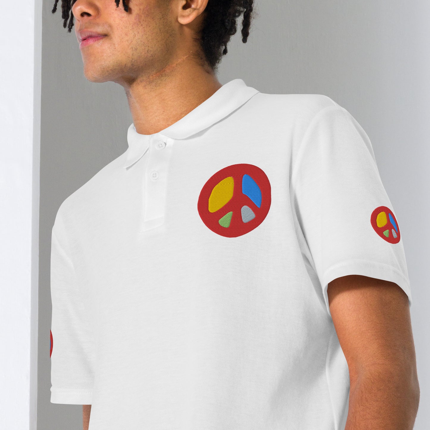 Close-up of unisex white polo shirt with peace sign embroidery